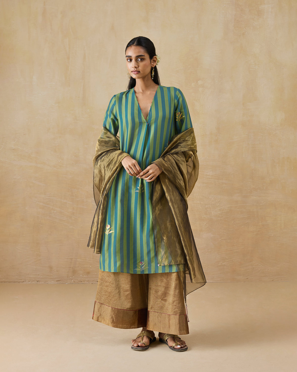 Person wearing a striped Front Pleated kurta with a sheer gold dupatta.