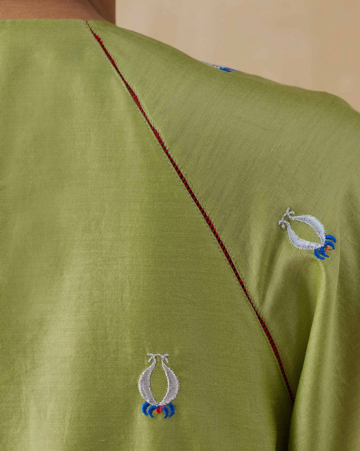 Close-up of red contrast stitching and motifs on the Revelry kurta shoulder.
