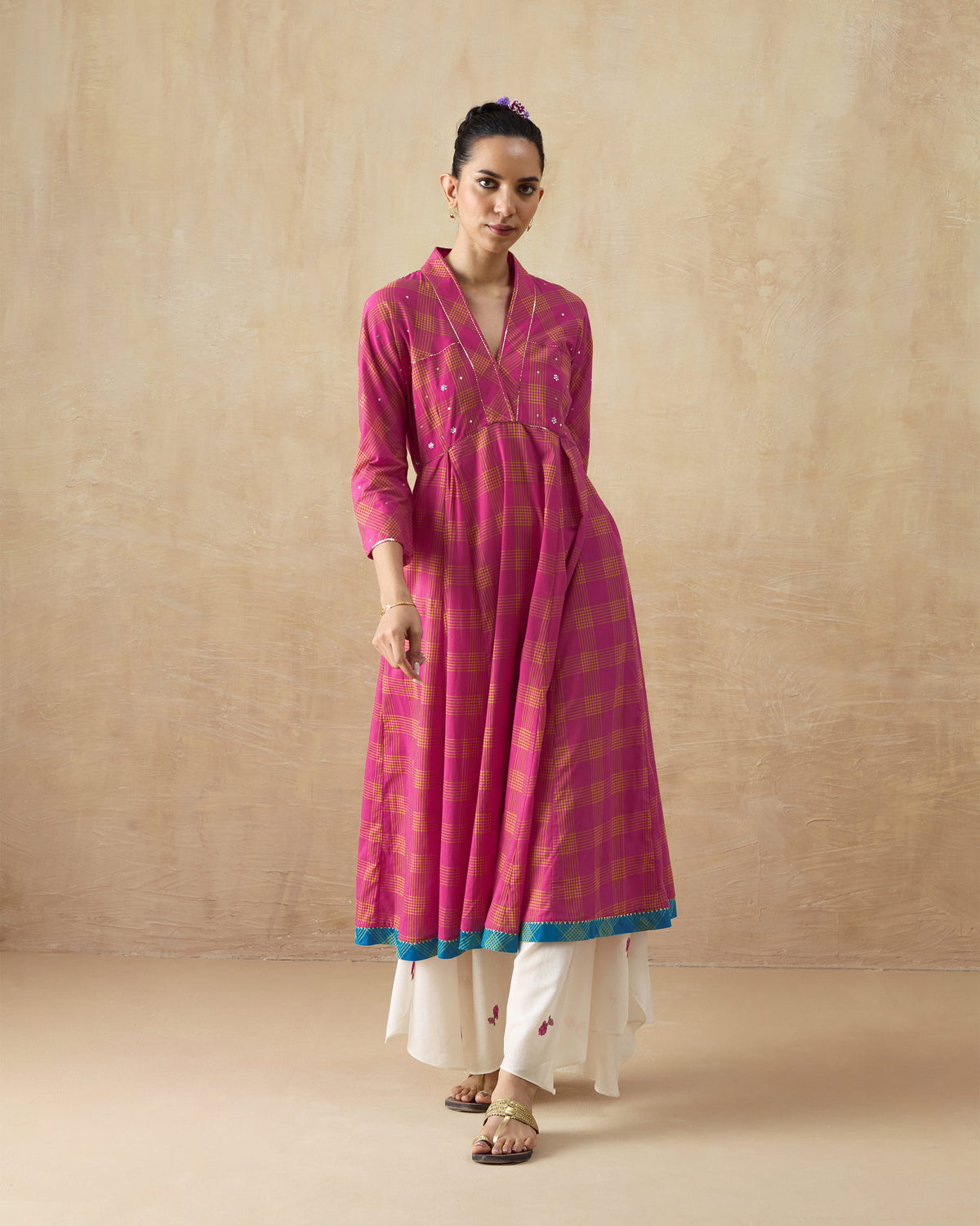 Person wearing a berry and lime check Drifter kurta with a turquoise hem border.