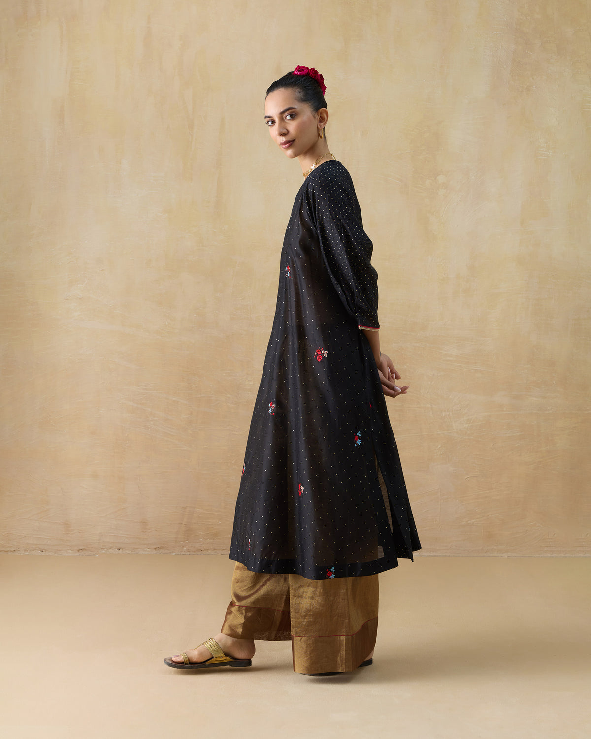 Side view of a black Moonbeam kurta with gold dots and floral embroidery.