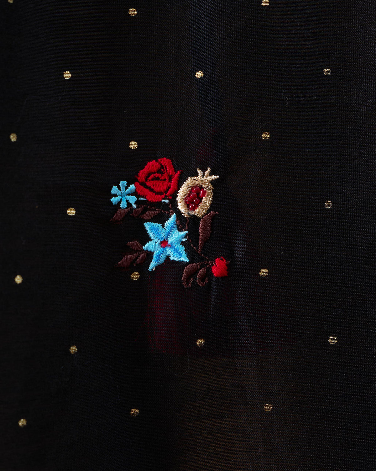 Close-up of rose and pomegranate embroidery on a black Moonbeam kurta.