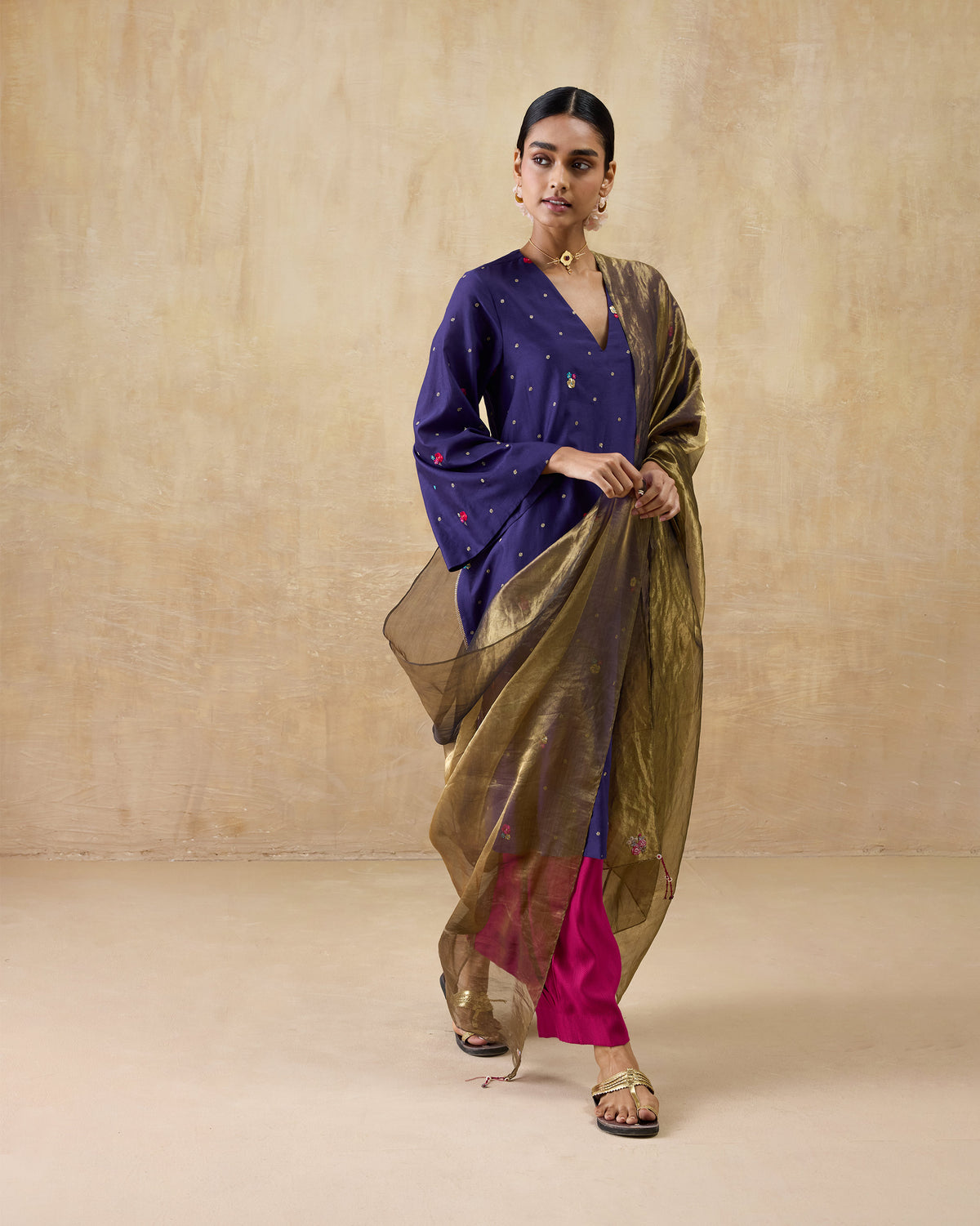 Person wearing a purple Nebula kurta with a gold dupatta.