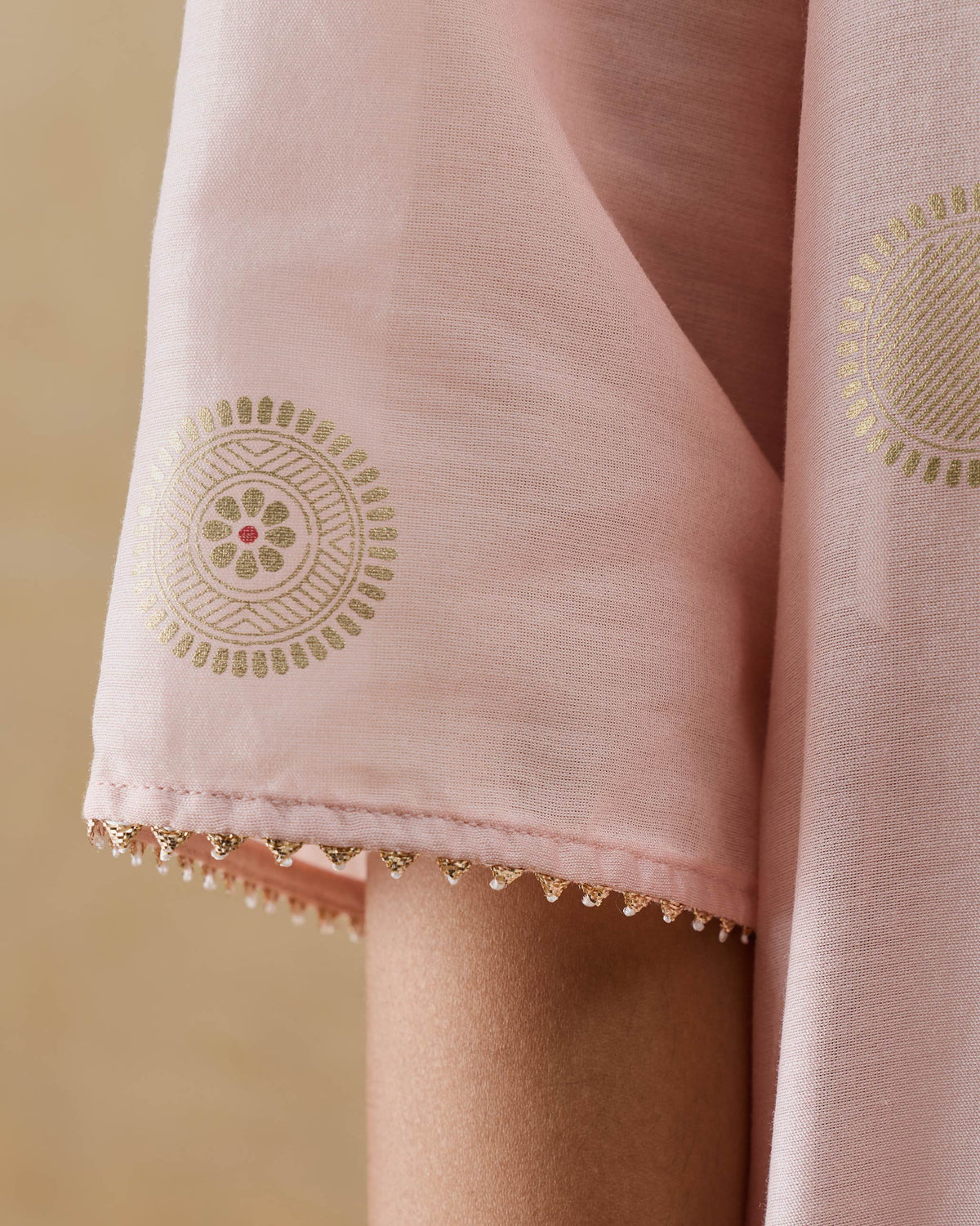 Close-up of a Radiant kurta sleeve with a gold Asharfi motif and beaded cuff.