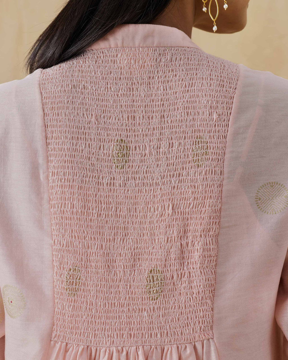 Close-up of smocking and gold dots on the back of a soft pink Radiant kurta.