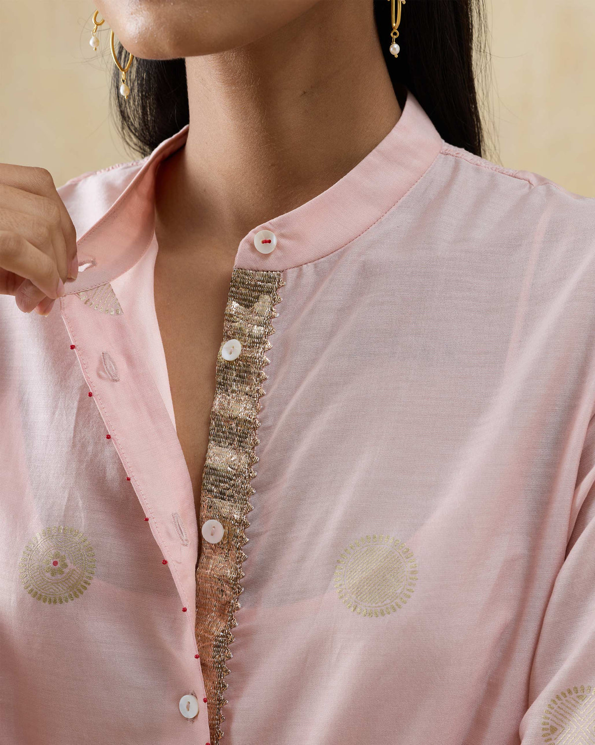 Close-up of gold lace trim on a soft pink Radiant kurta placket.