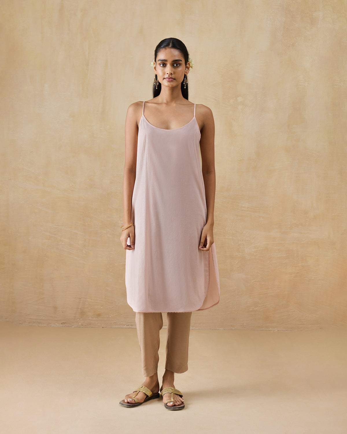 Person wearing a soft pink sleeveless slip tunic.