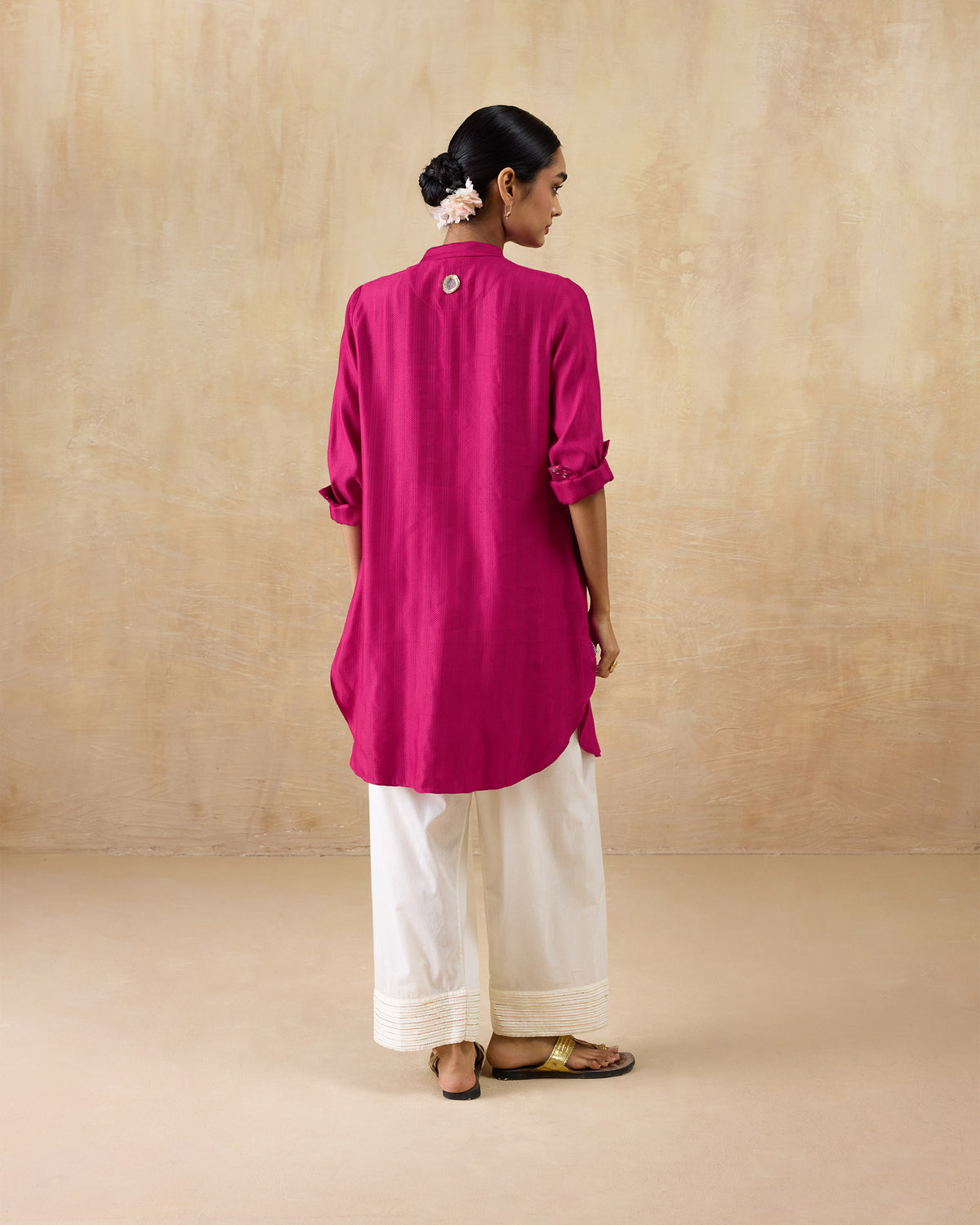 Back of a berry pink mid-length kurta with a silver embroidered motif.