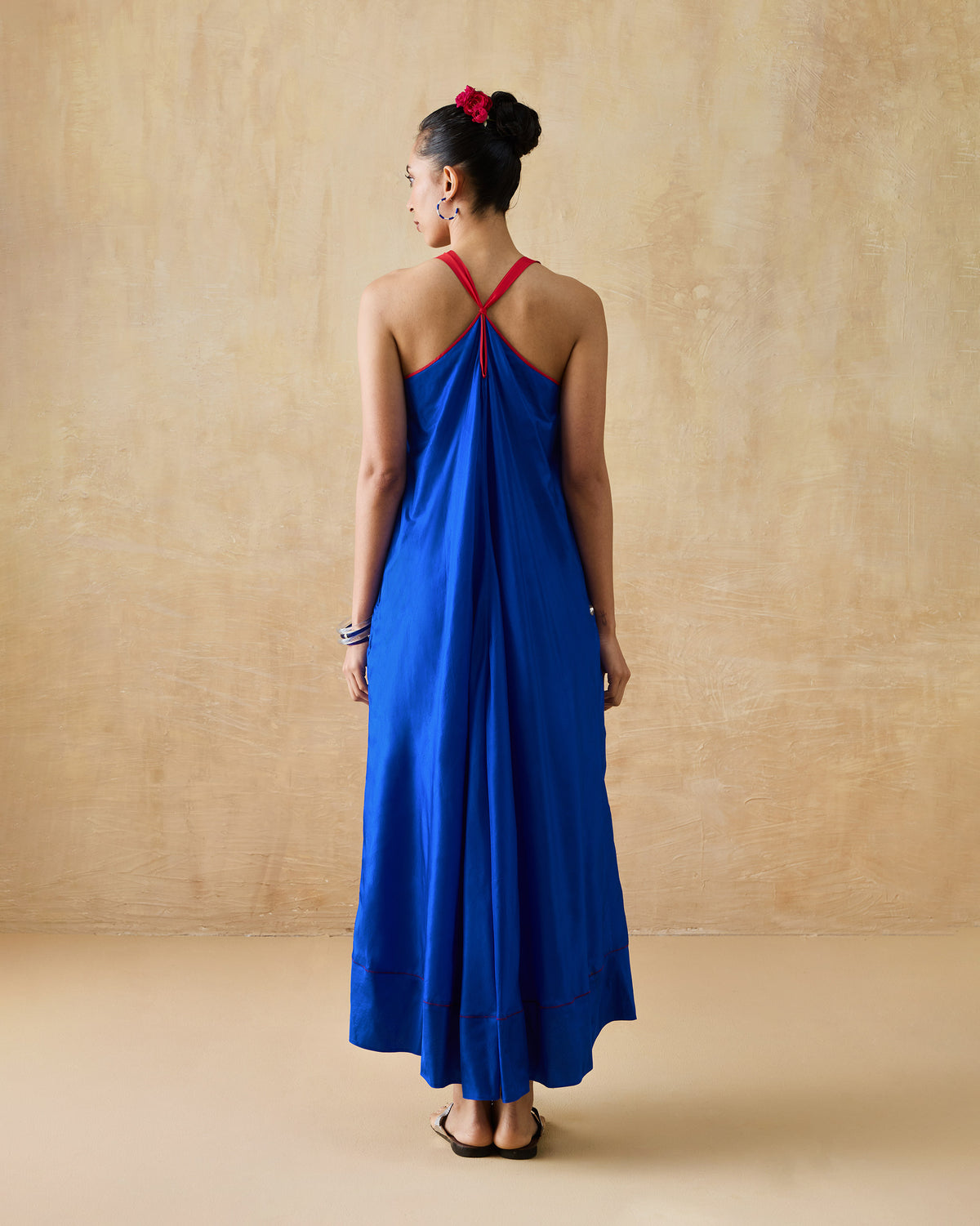 Back of a cobalt blue Akira Twist Back Dress with red twisted straps.