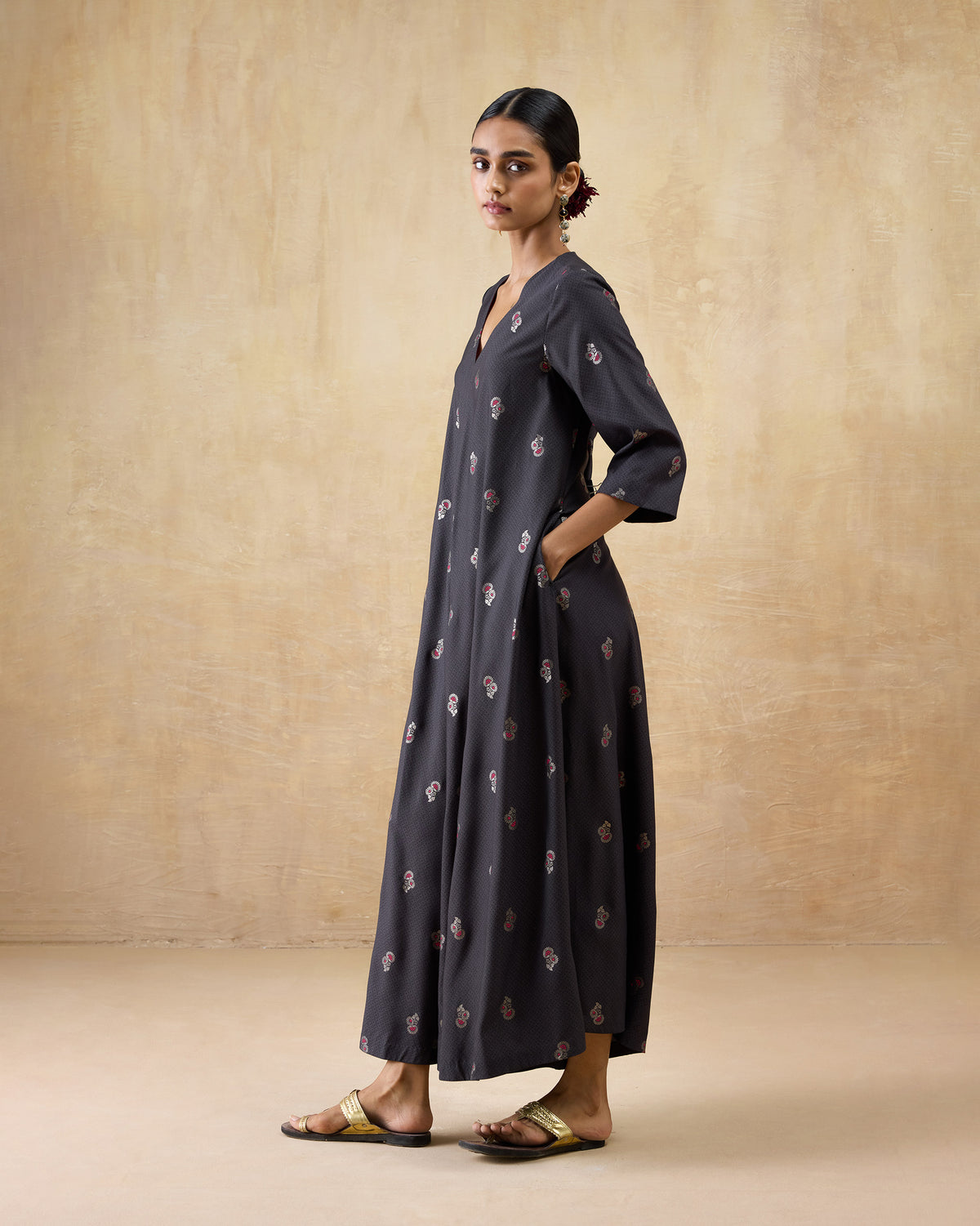 Three-quarter view of a charcoal Bash jumpsuit with pink floral print.