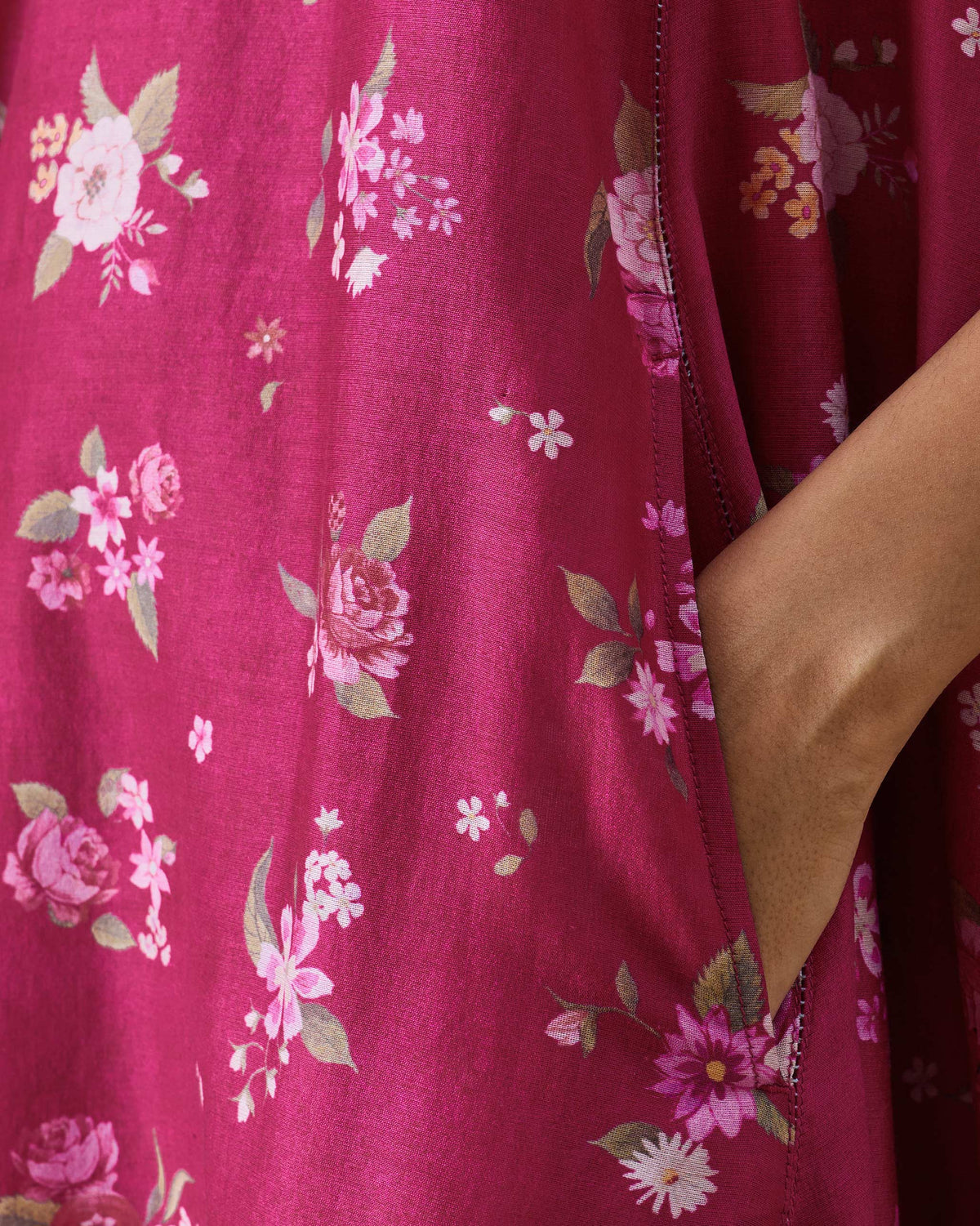 Close-up of berry rose print and a side pocket on a Lumen dress.
