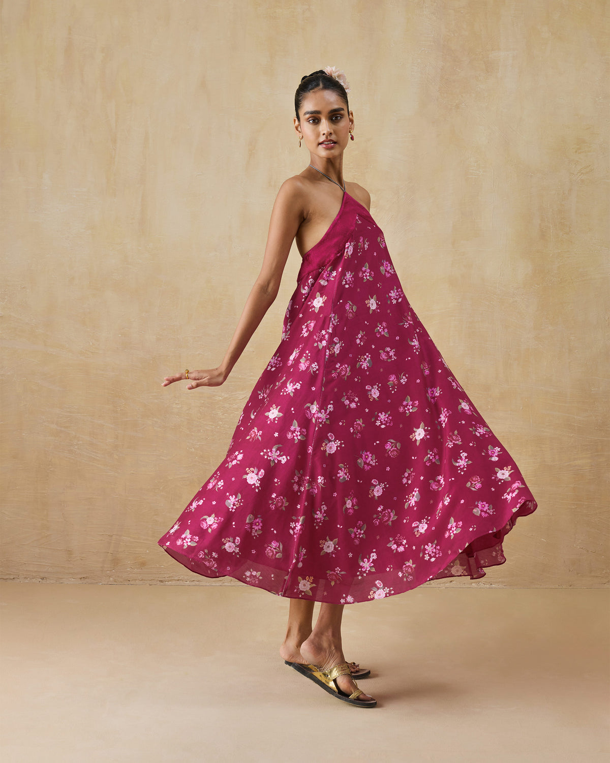 Person wearing a berry floral Lumen dress with a halter neckline.