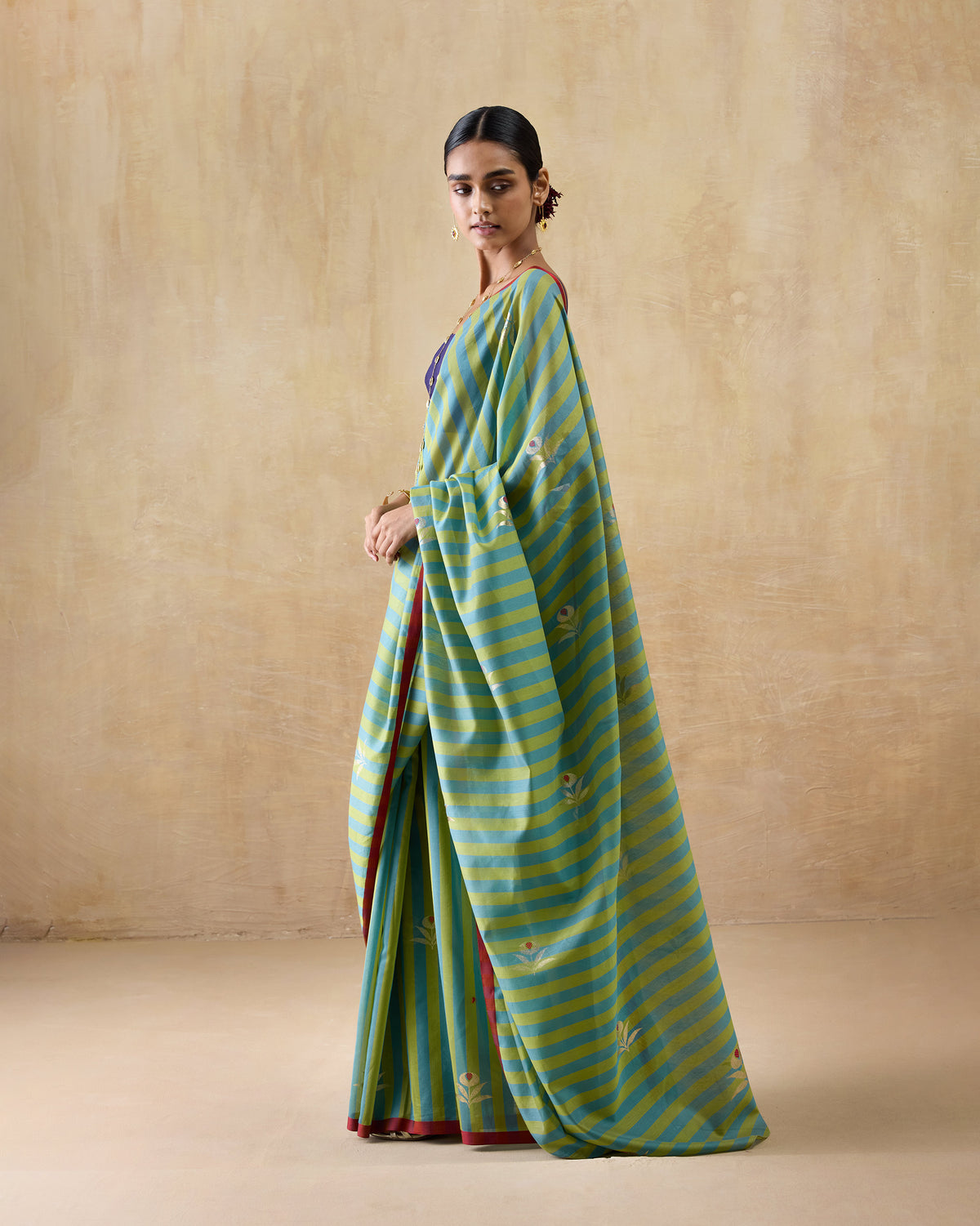 Three-quarter view of a leaf green and teal Garden Party Sari with the pallu draped.
