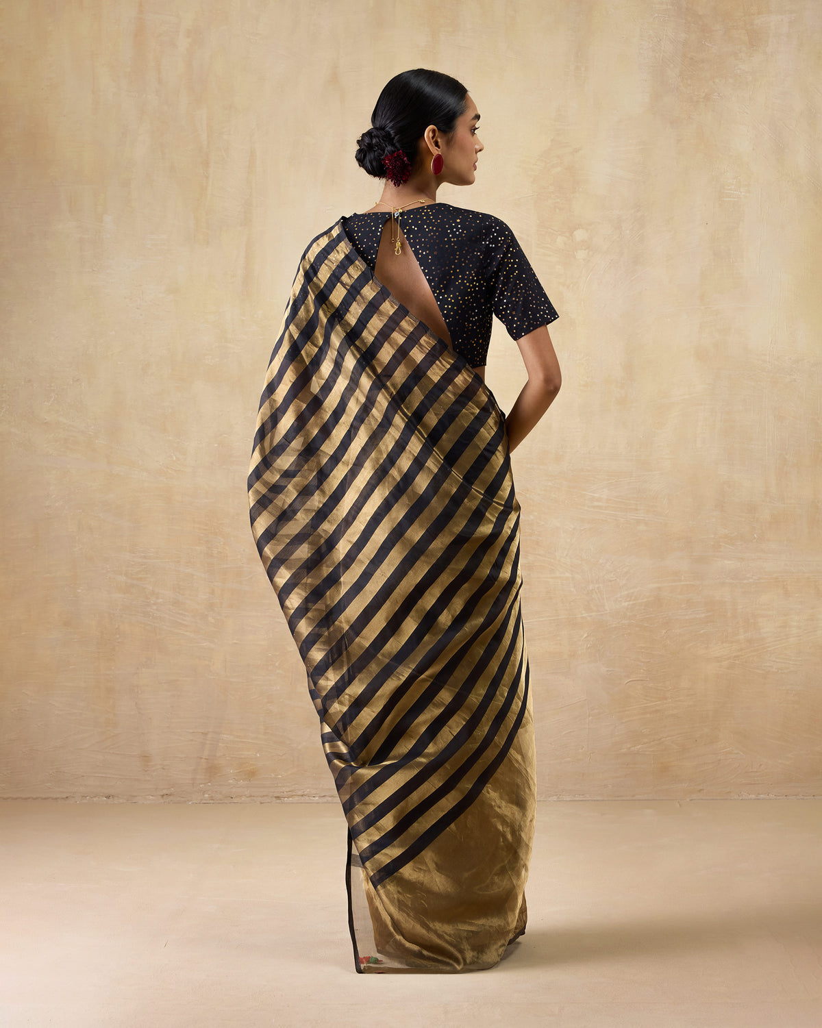 Back of a gold Dancefloor Sari with black striped pallu.