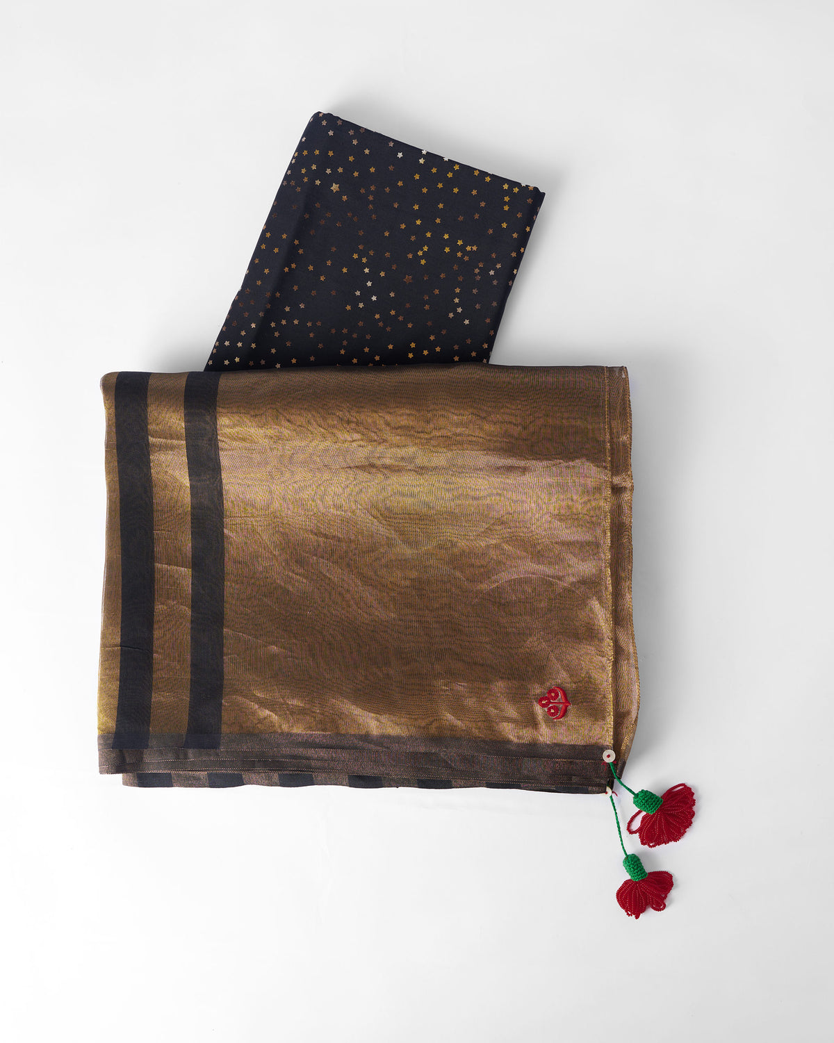 Gold Dancefloor Sari laid flat with black stripes and red tassels.