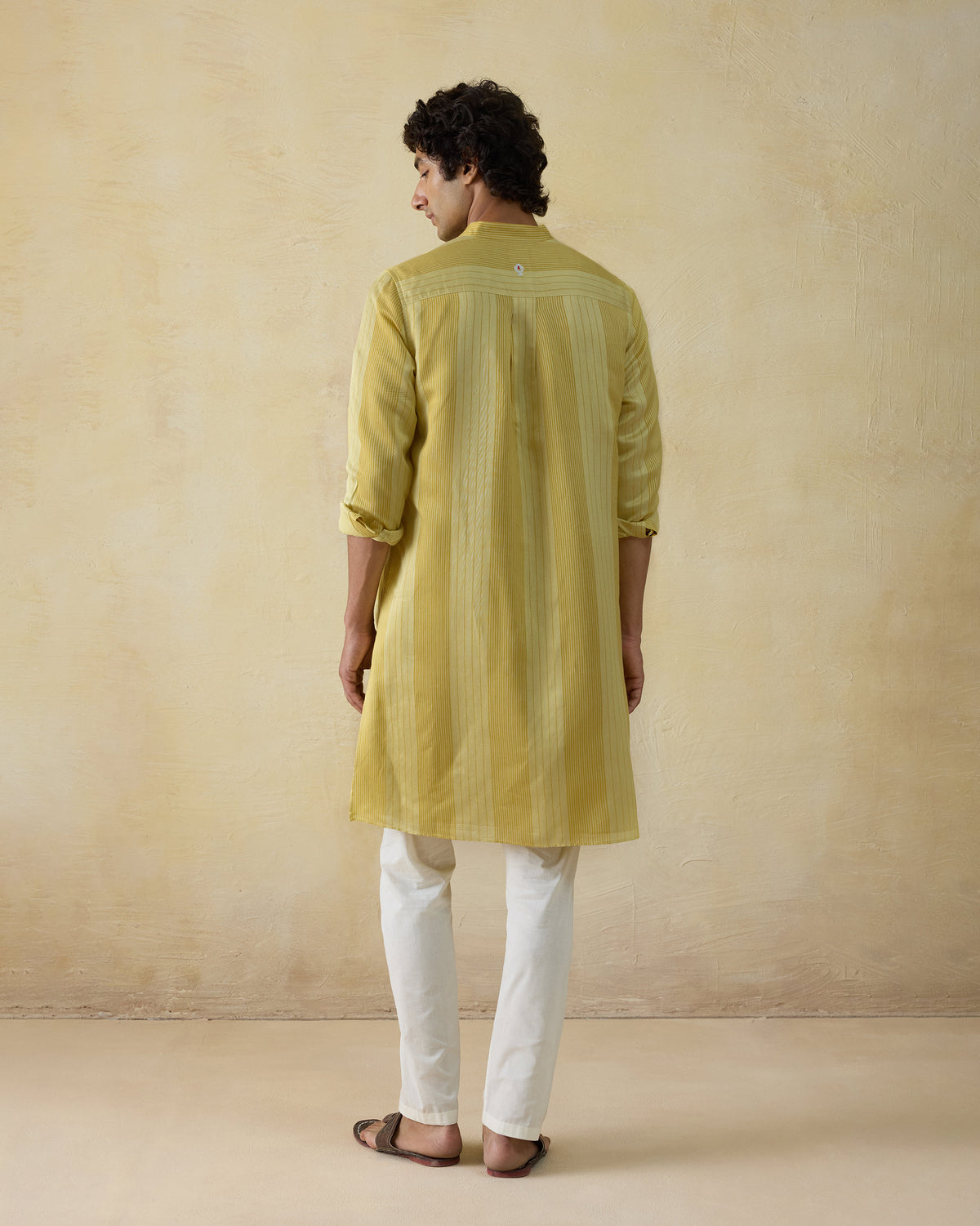 Back of a mustard striped Voyage Kurta with a zari anaar at the yoke.