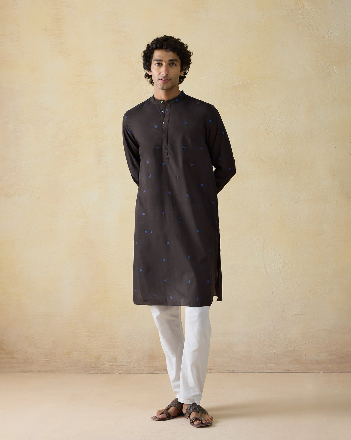 Person wearing a brown Gala Kurta with blue star dots.