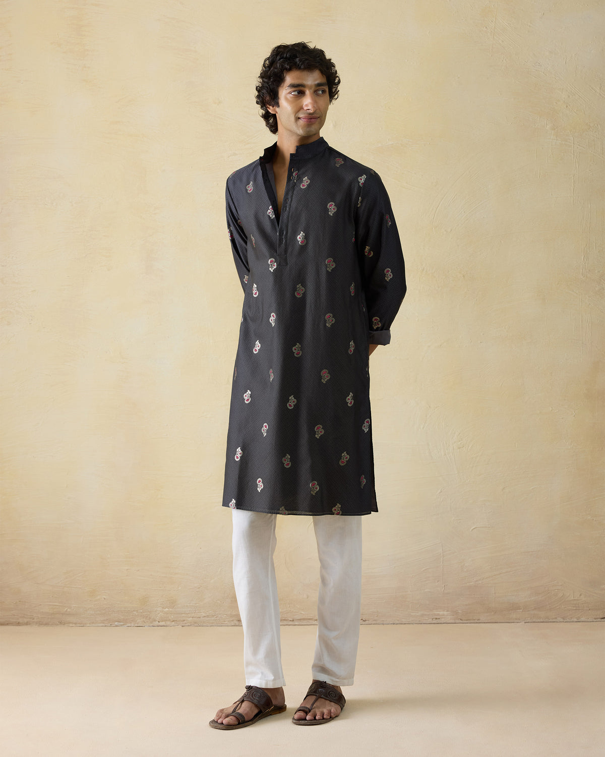 Person wearing a black printed Rey kurta with a mandarin collar.