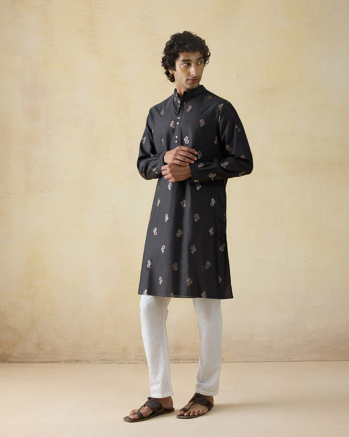 Full-length view of a black printed Rey kurta worn with white trousers.