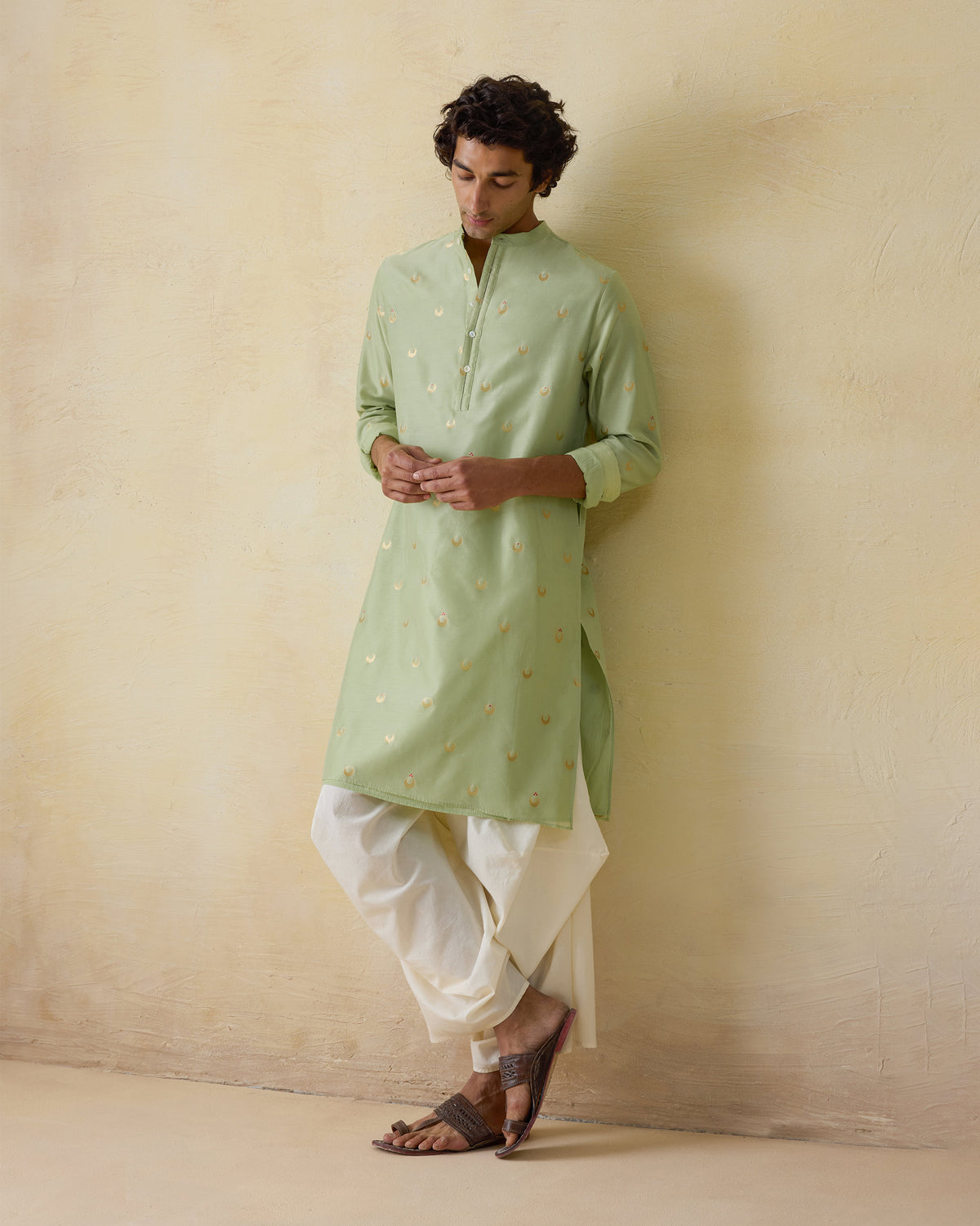 Person wearing a mint green astral kurta with gold valley motifs.