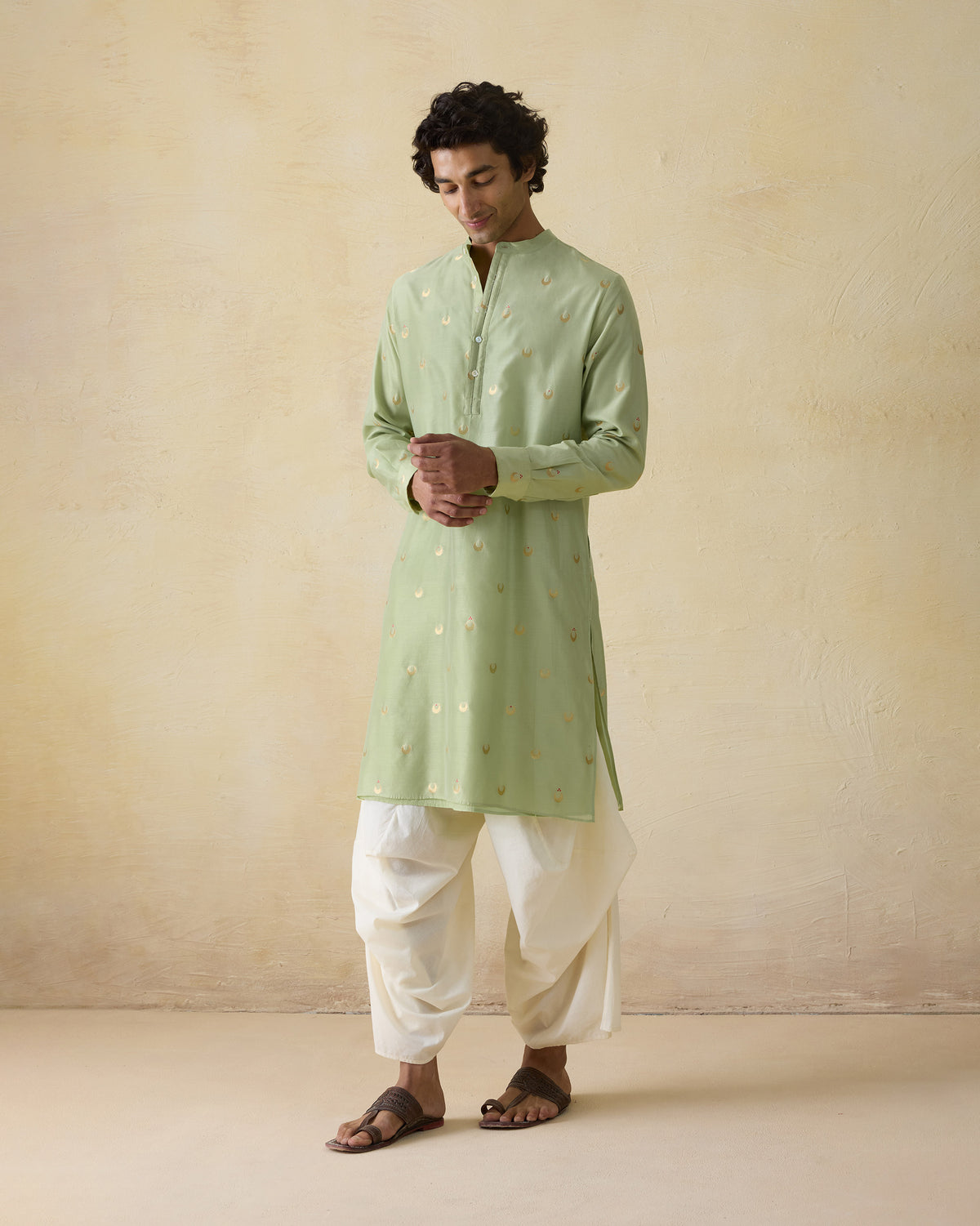 Person wearing a mint green astral kurta with full sleeves and gold valley motifs.