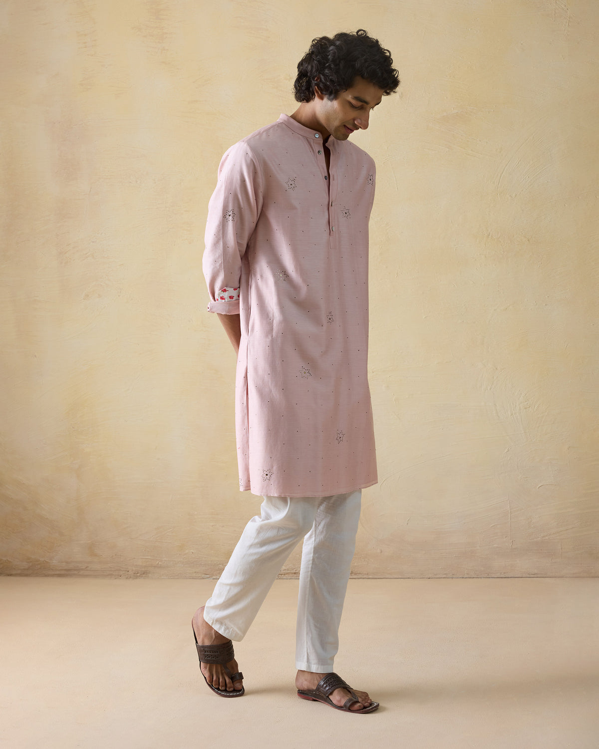 Person wearing a light pink Arham kurta with side slits.