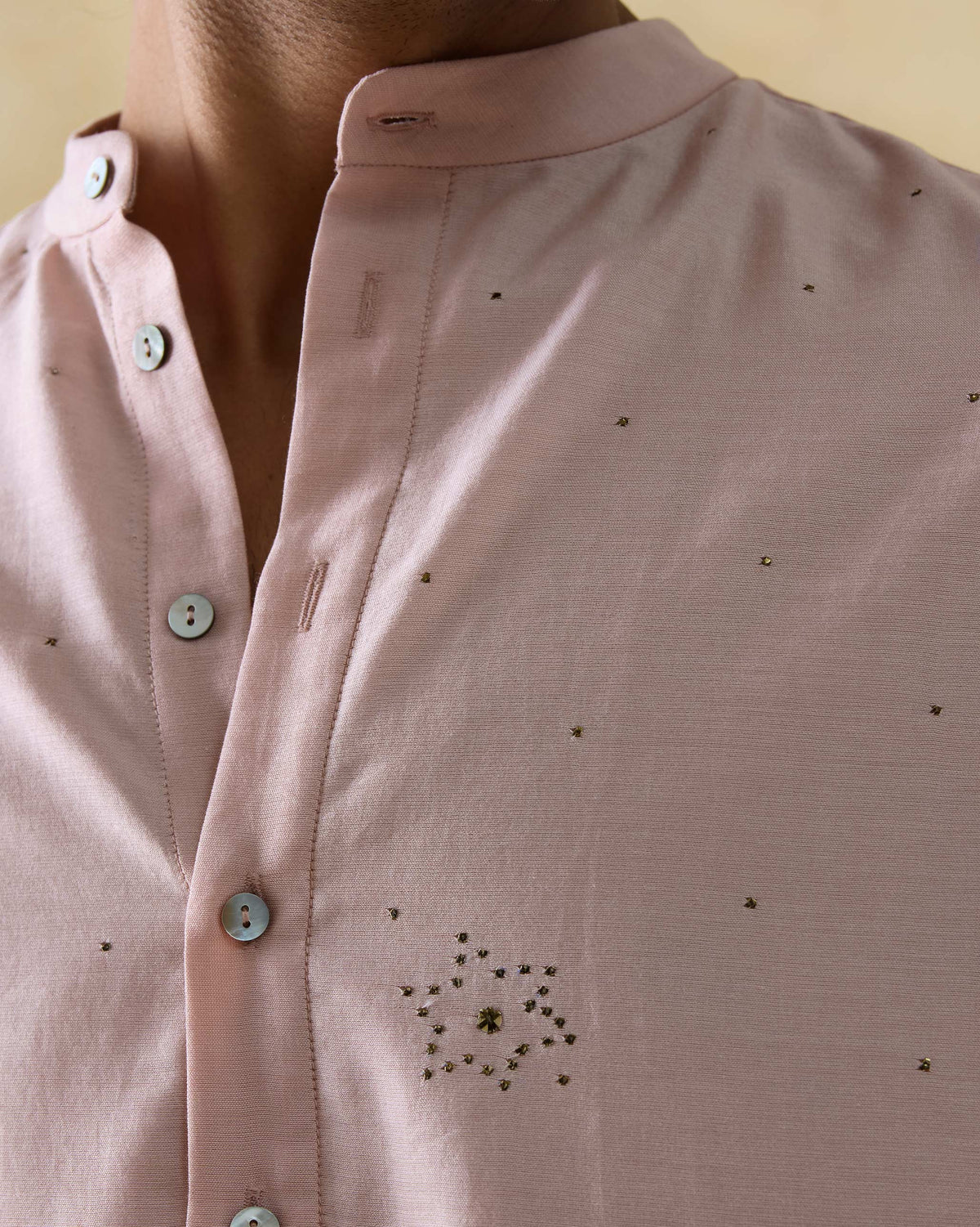 Close-up of a light pink Arham kurta showing a mukaish star on the chest.