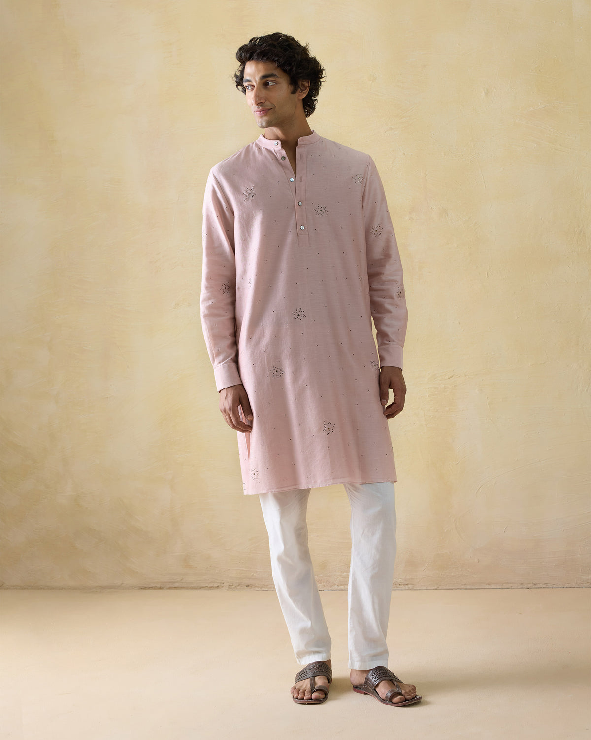 Person wearing a light pink Arham kurta.