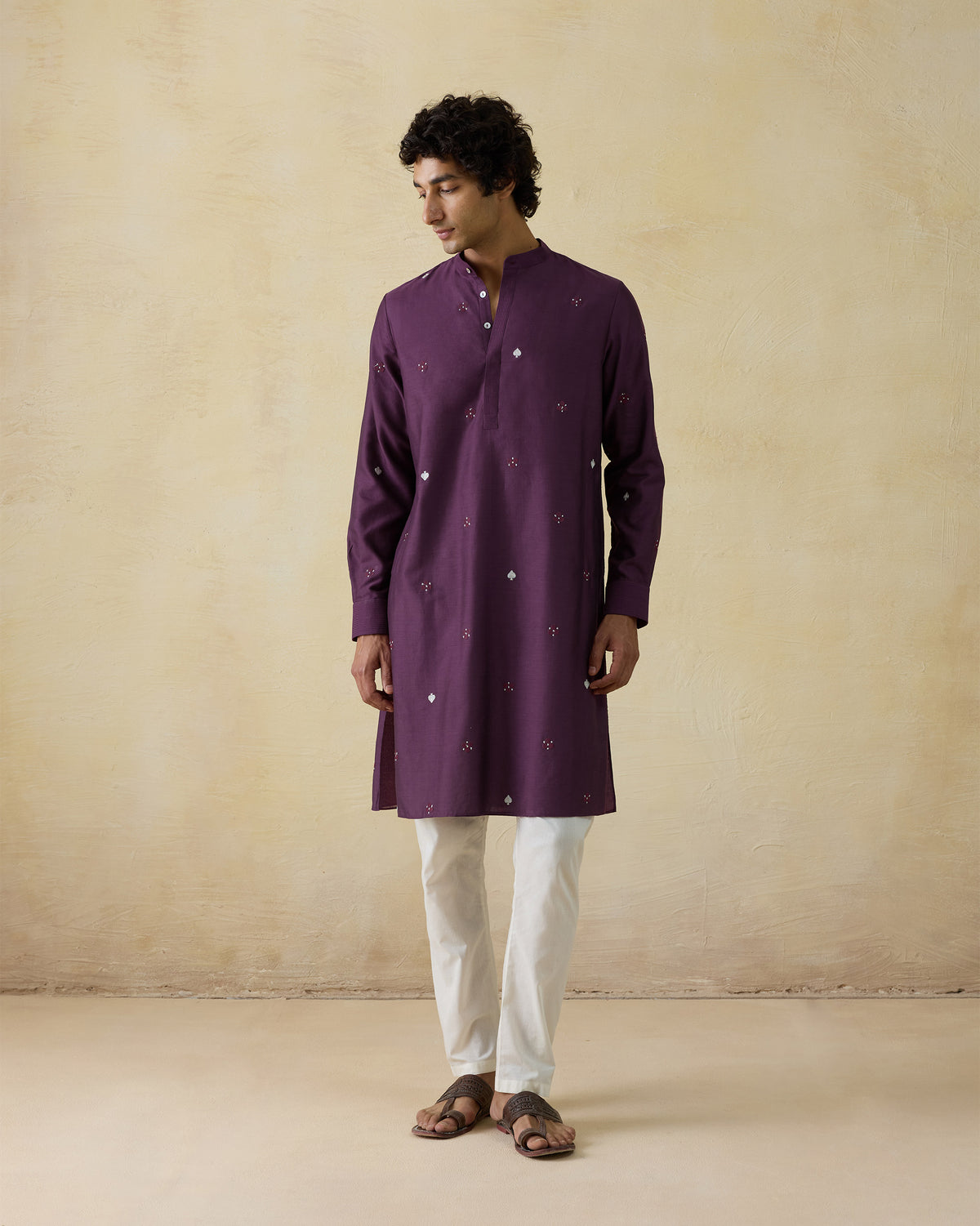 Person wearing a jamun pink Neckband Kurta with a band collar and embroidered motifs.