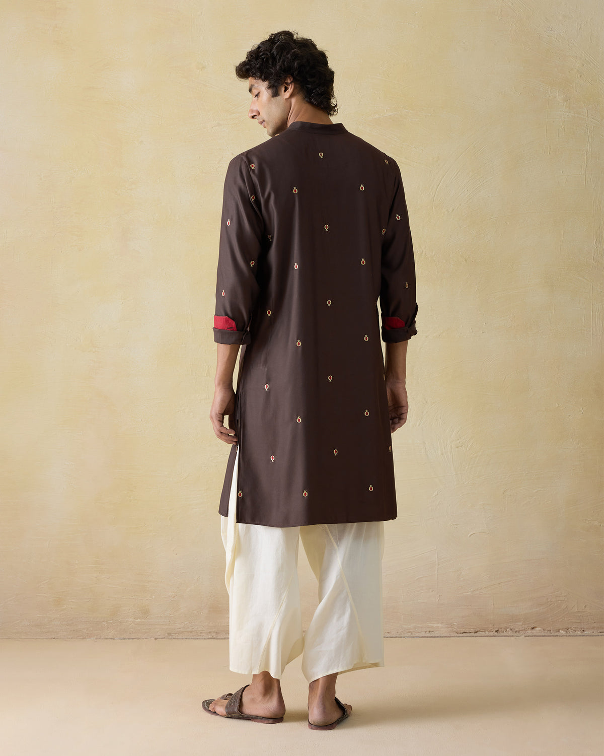 Back of a dark brown neckband kurta with all-over embroidered motifs.