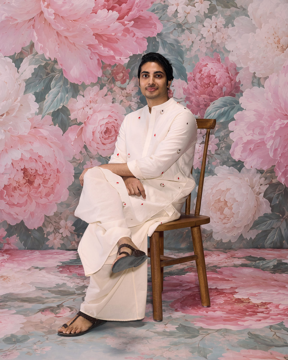 Person wearing an ivory Neckband Kurta with scattered red and silver embroidery.