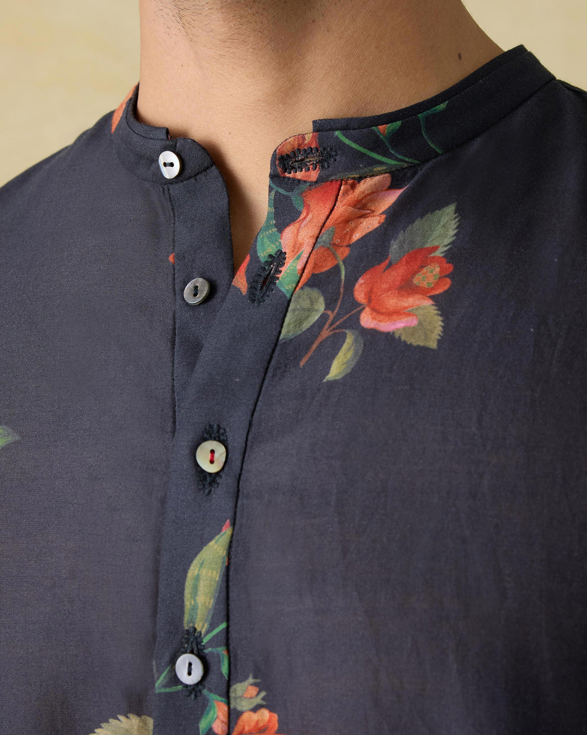 Close-up of the band collar and floral print on a charcoal Ibn kurta.
