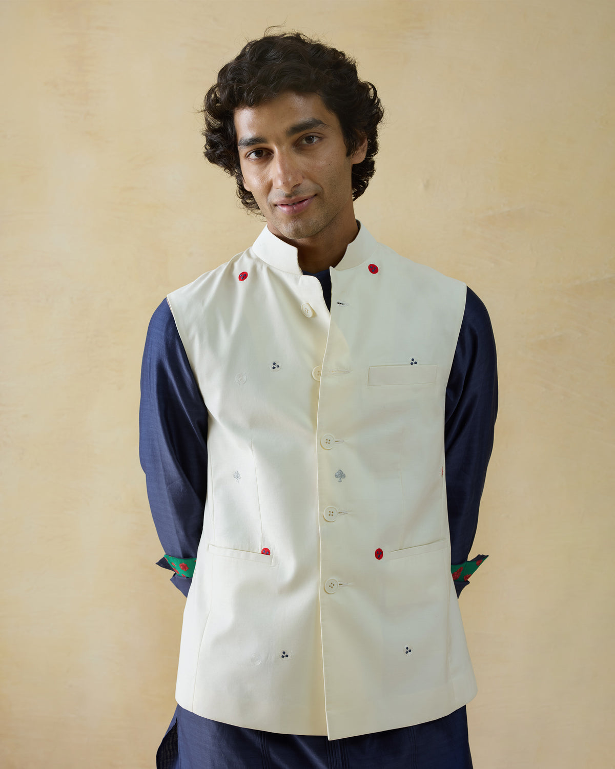 Person wearing an ivory Nehru Jacket with a Nehru collar and chest pocket.