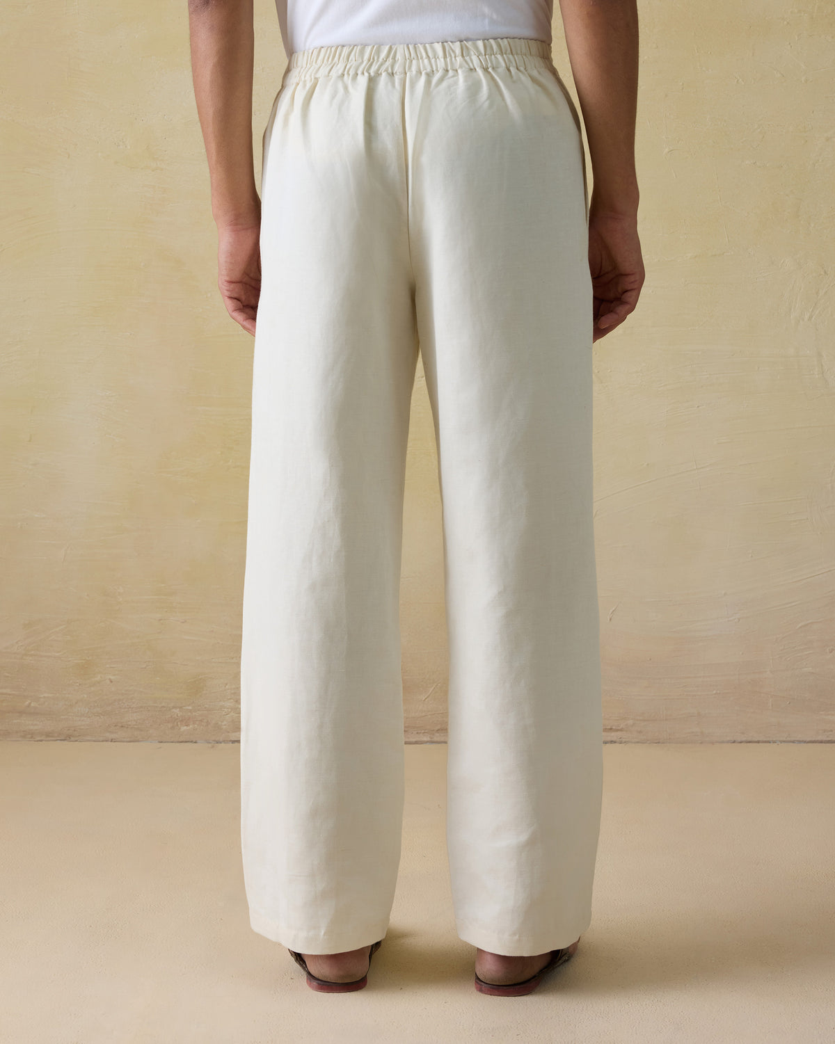 Back of ivory Aaram pants with a gathered elastic waistband.