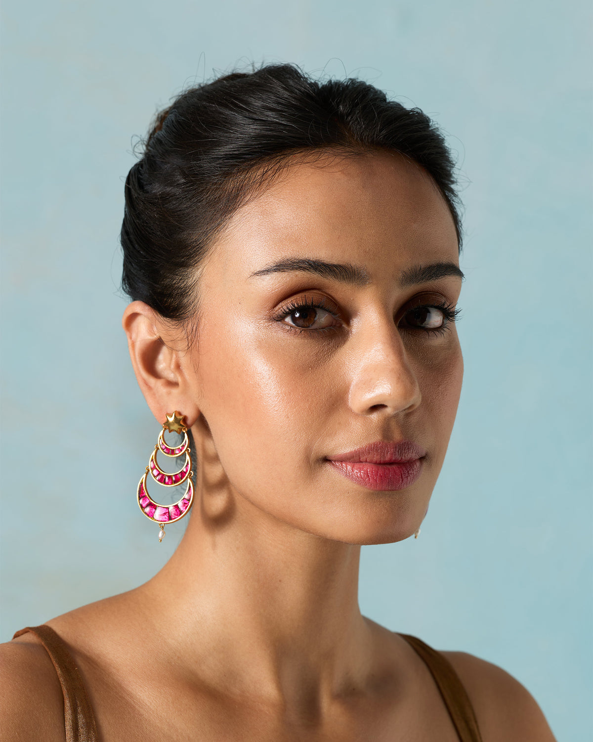 Person wearing a Gul-Chand Earring with stacked pink crescents below the ear.