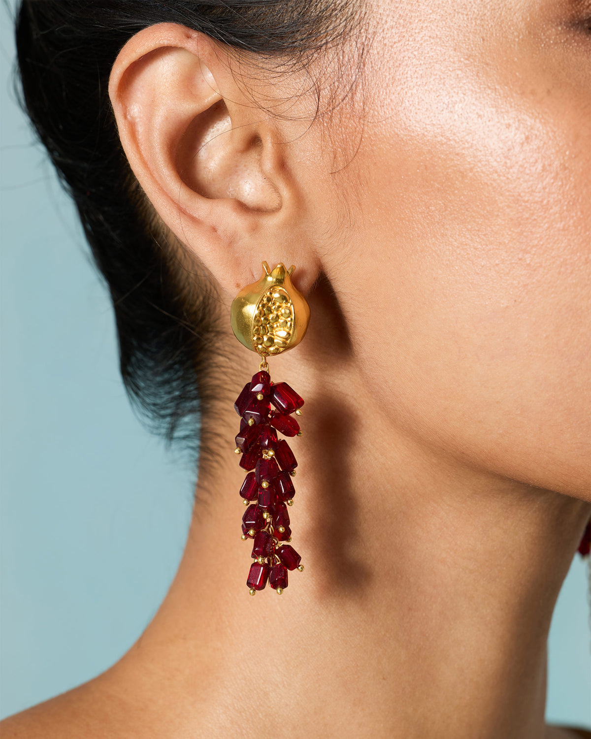 Close-up of Anaar Bagicha Earring worn, showing the gold pomegranate top and red drop.