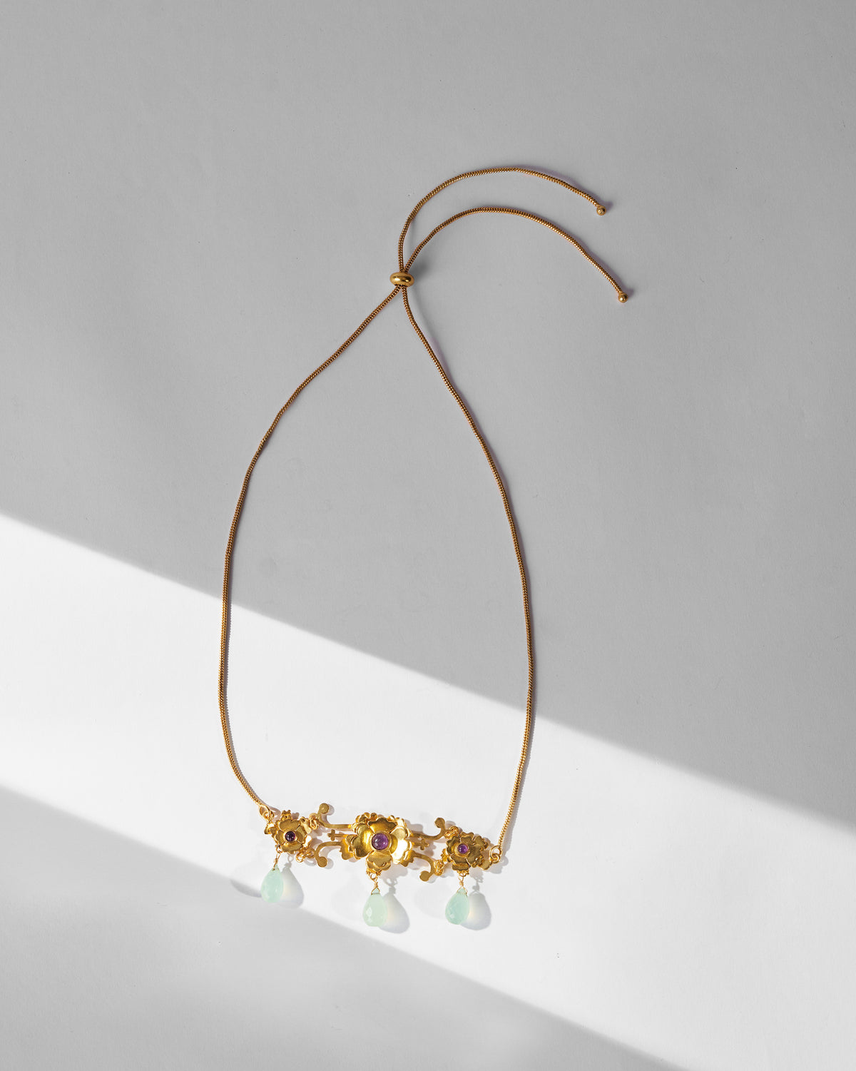 Gold Kesar choker laid flat, showing its adjustable cords.