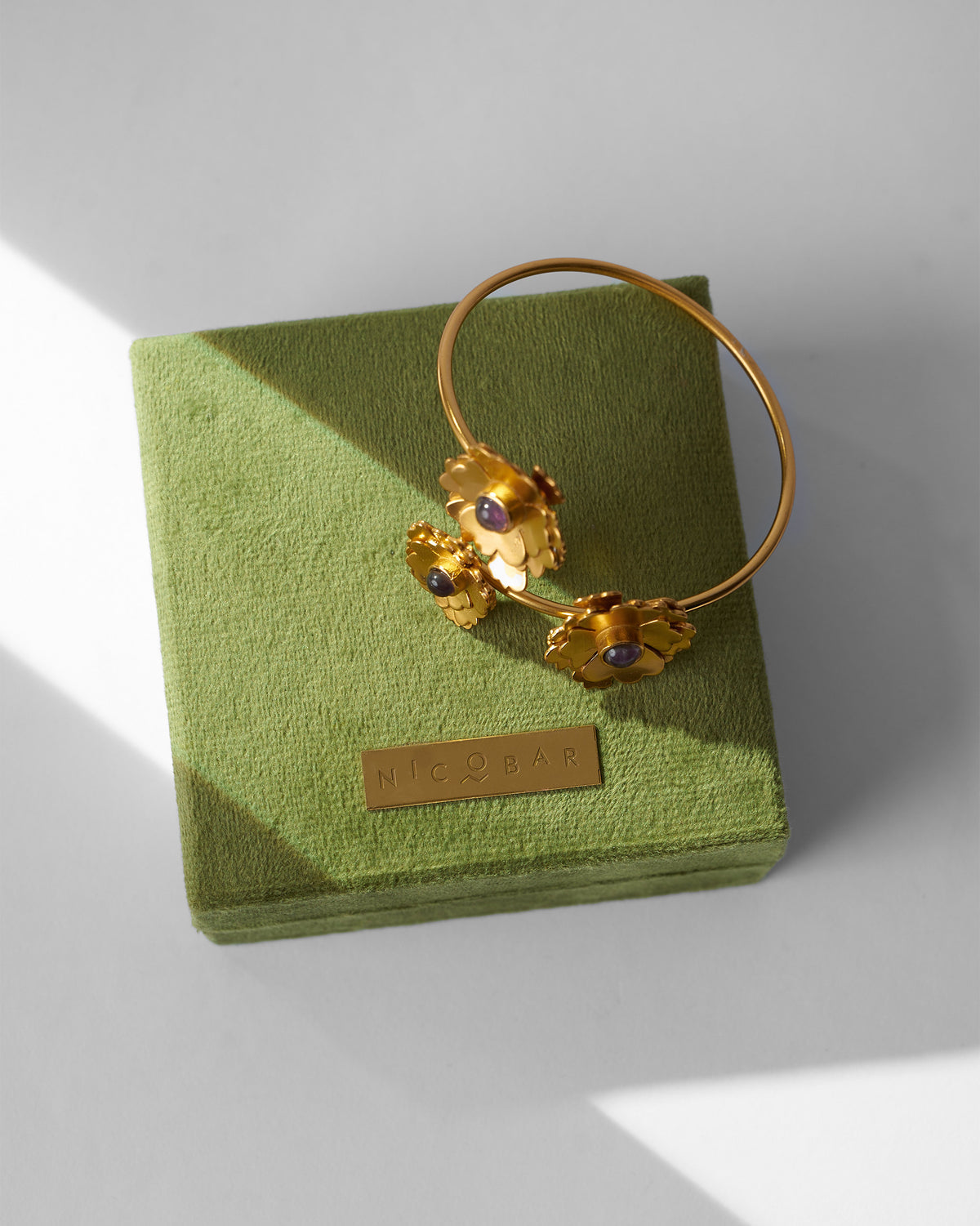 Kesar Phool Cuff resting on a green velvet box.