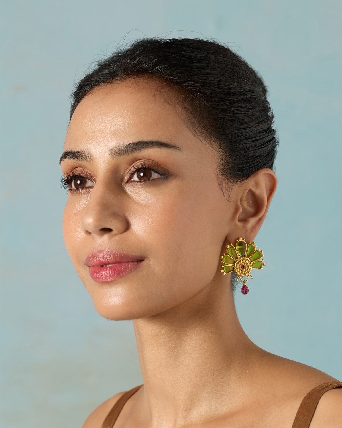 Person looking aside, wearing a Mari-Palm earring with green petals.
