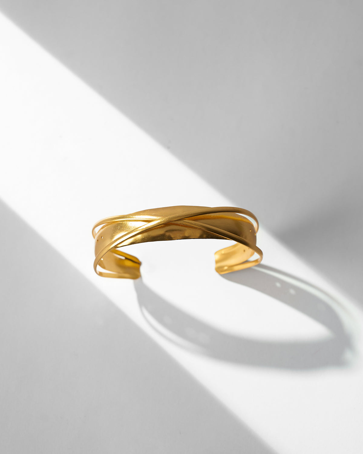 Kaveri Bangle with a twisted gold band and an open end.