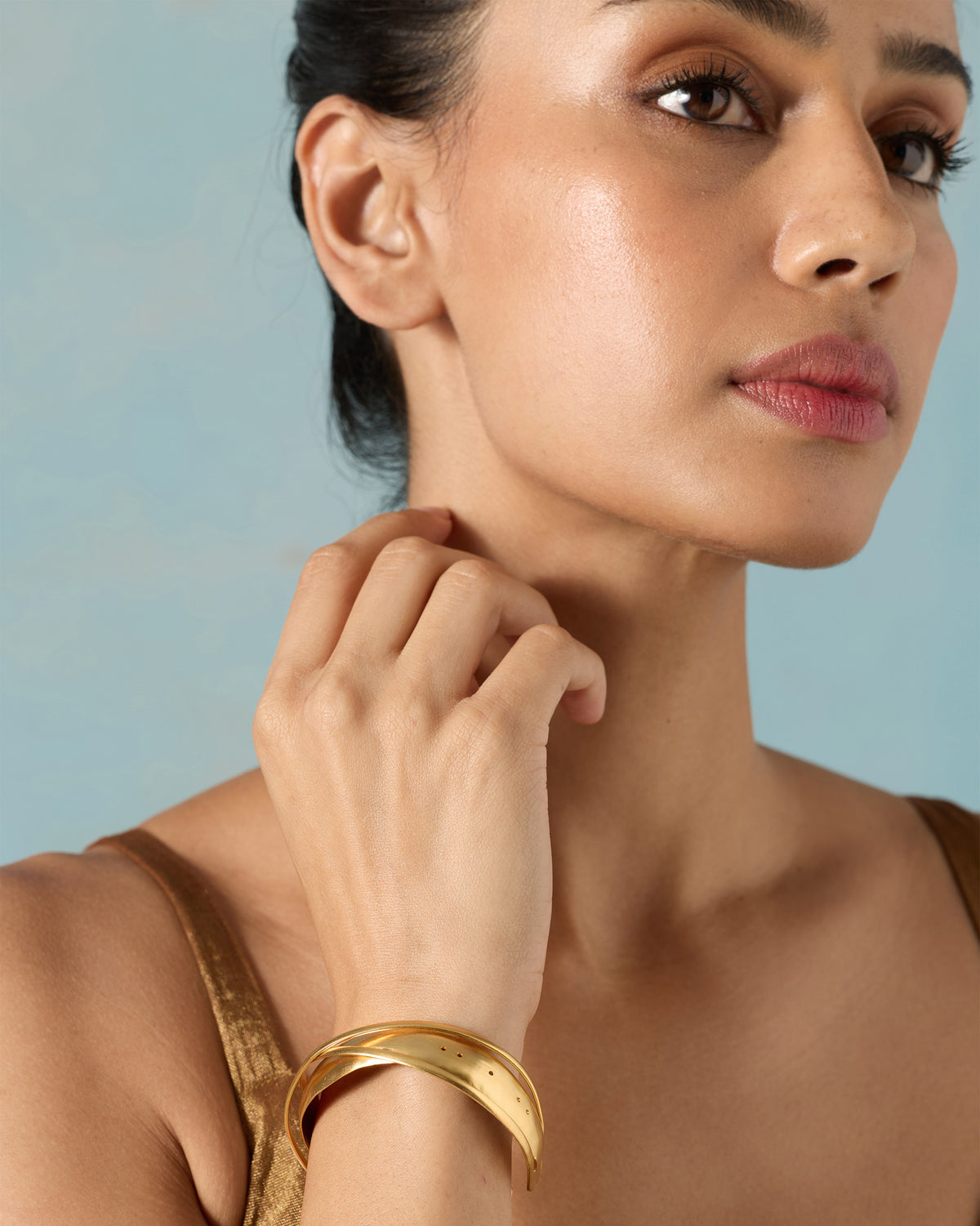 Upper body of a person wearing a Kaveri Bangle on one wrist.