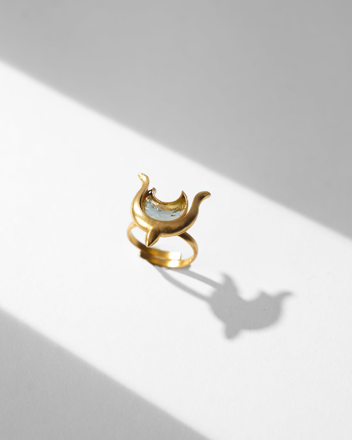 Gold Chandphool ring with a crescent moon motif on a white surface.