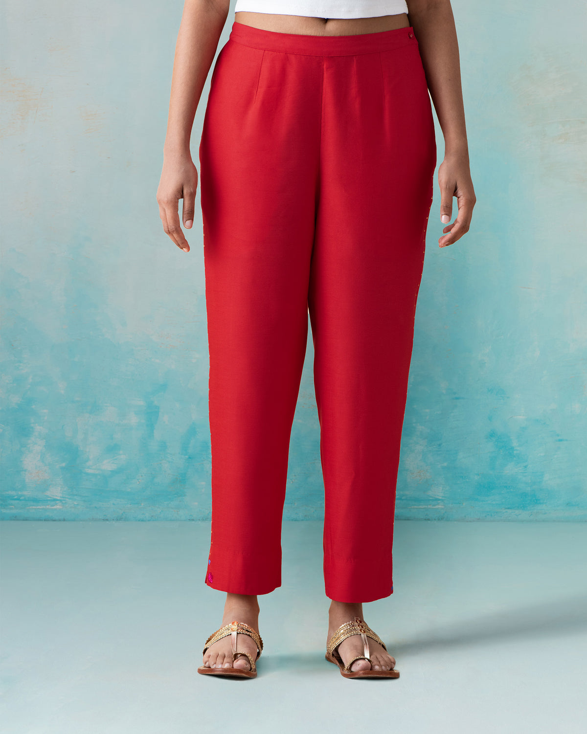 Person wearing bright red Novel pants with a narrow straight fit.