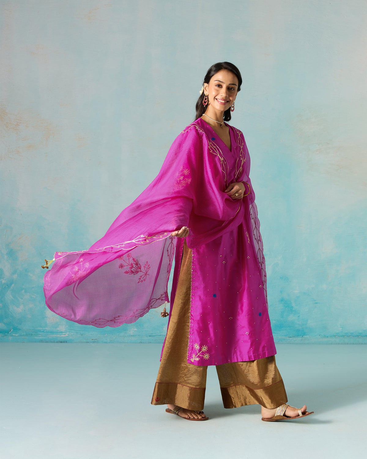 Person with a magenta Ishara dupatta flowing out to one side.