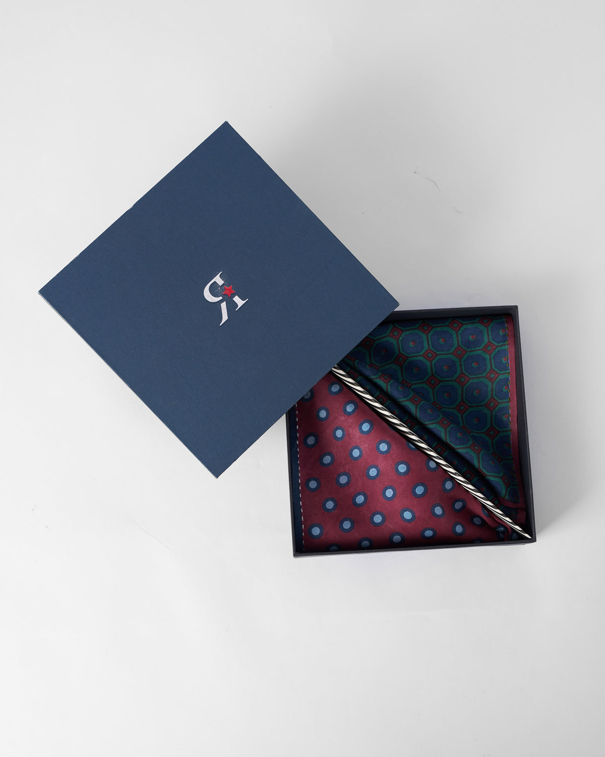 Pipit silk pocket squares presented in an open navy gift box.