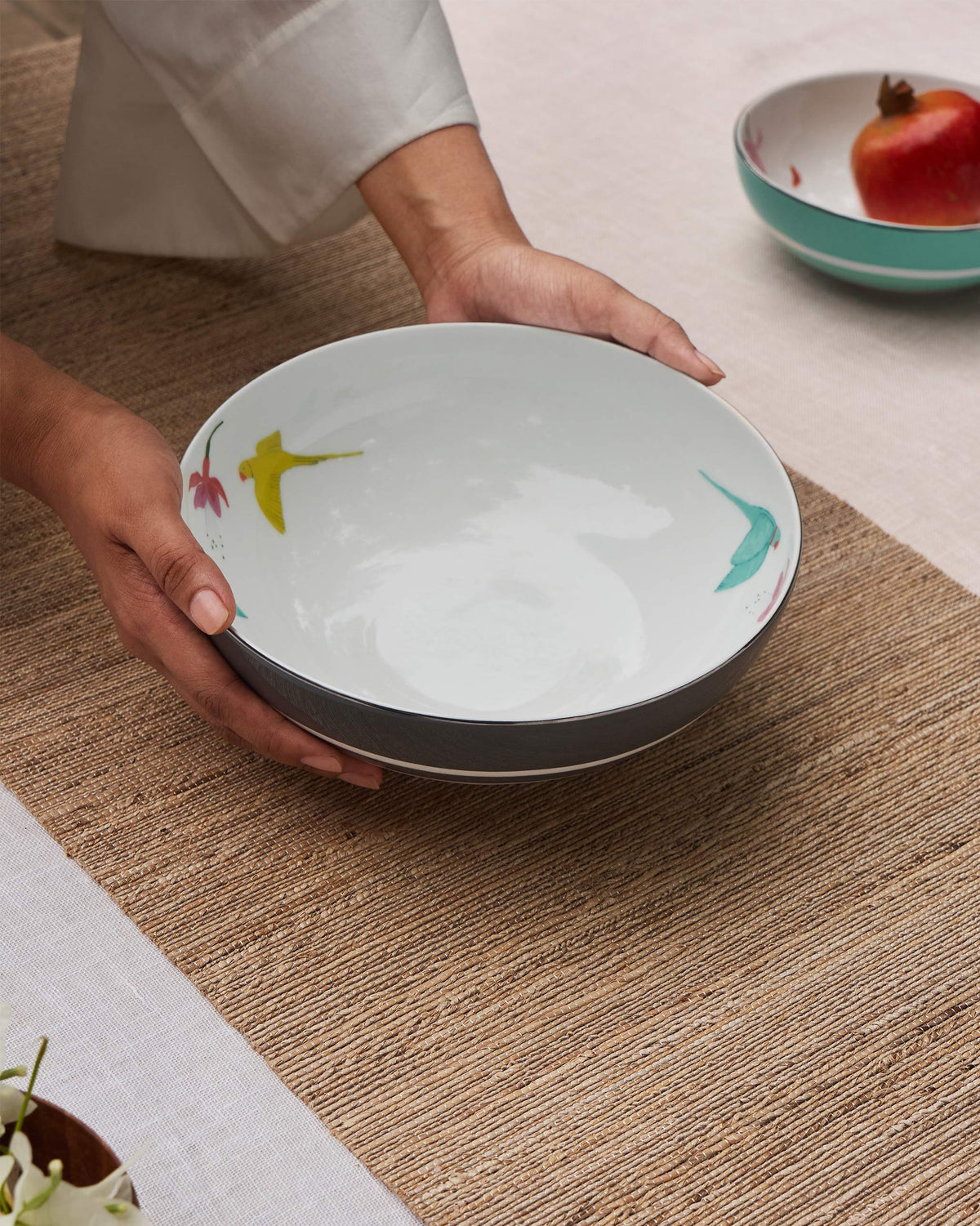 Person holding a Botanical Serving bowl large with painted birds inside.