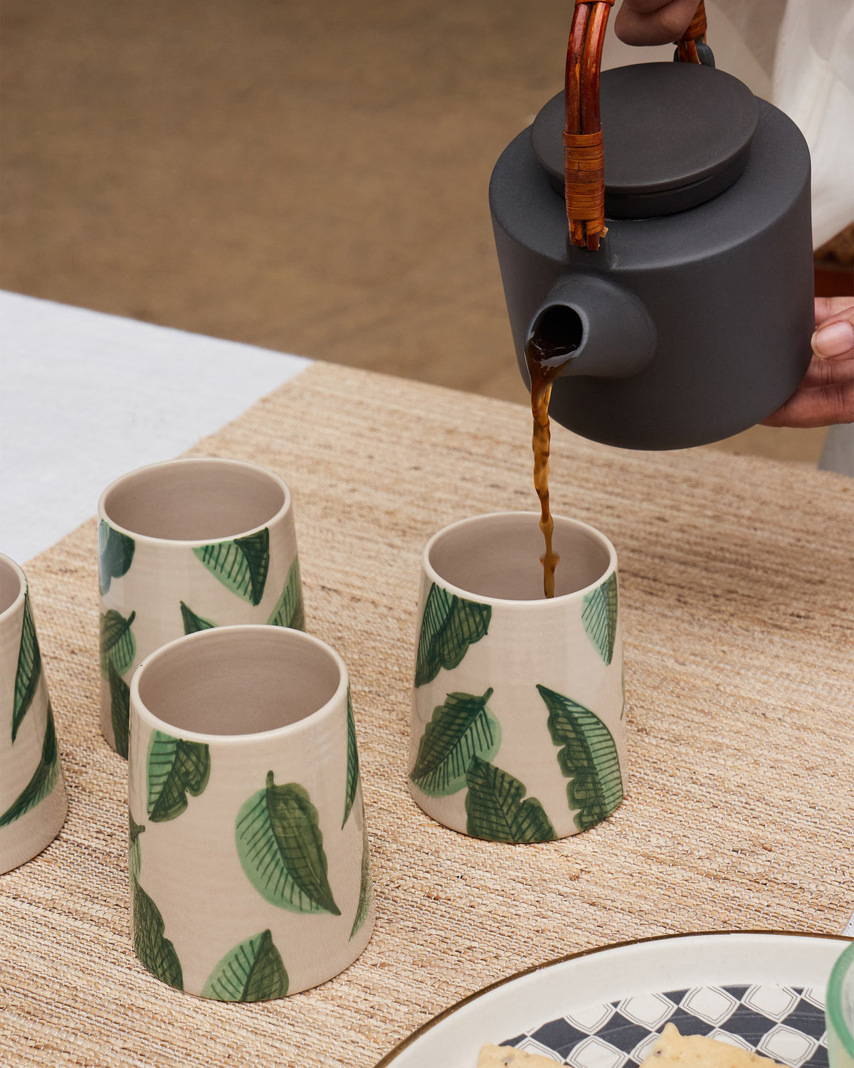 Galle kulhars with green banana leaf print as tea is poured.