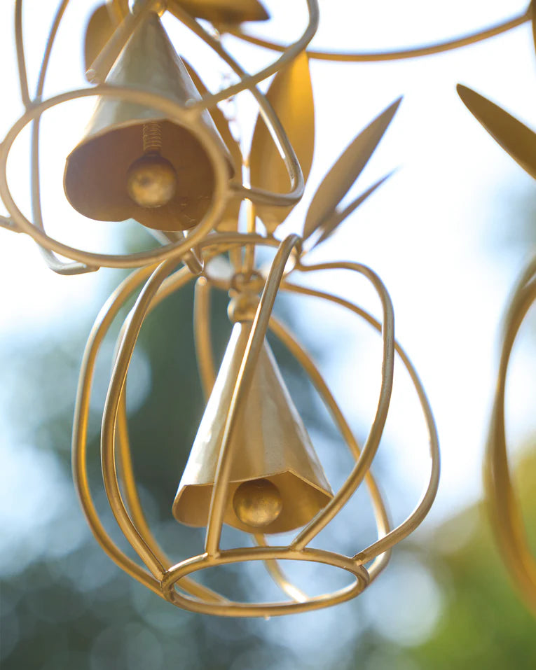Close-up of a gold pineapple wind chime bell inside its wireframe cage.