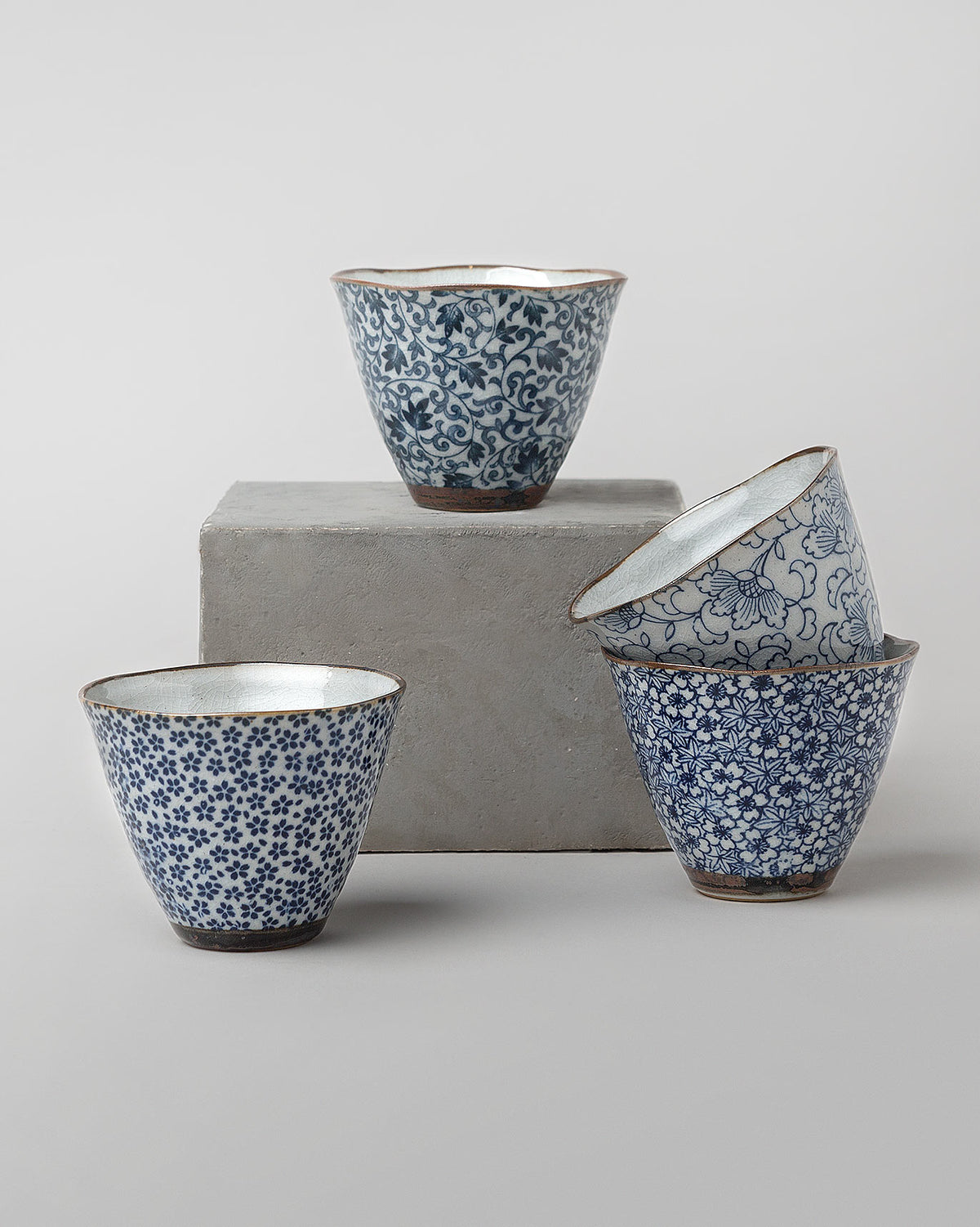 Set of four Ocha tea cups in blue and white floral patterns.