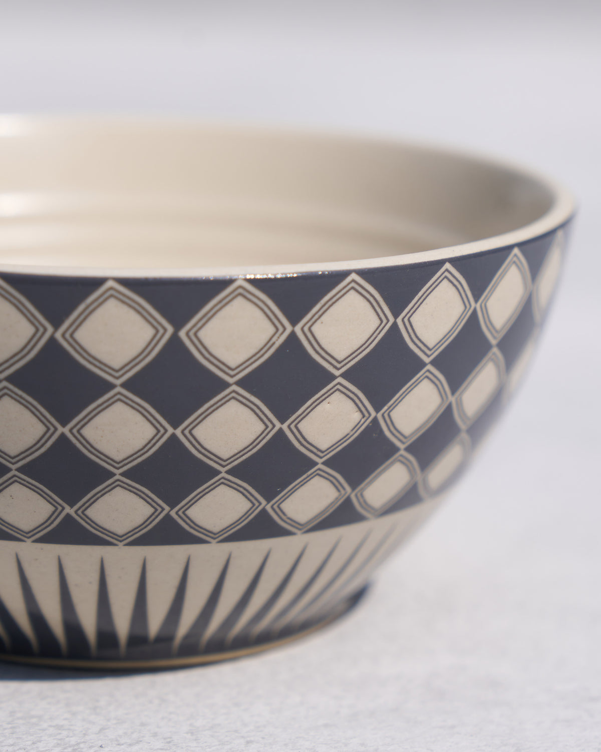 Close-up of a Fez cereal bowl showing navy diamonds and base spikes.