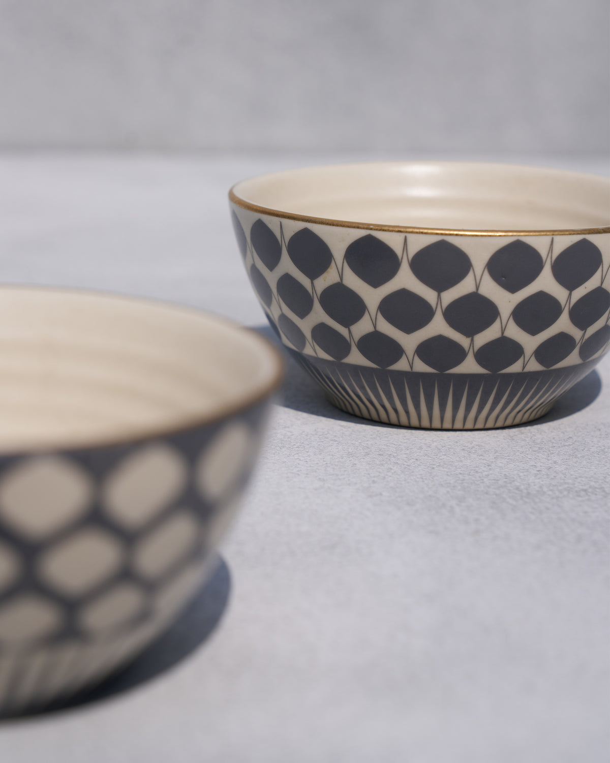 Fez nut bowl with a gold rim and charcoal teardrop pattern.